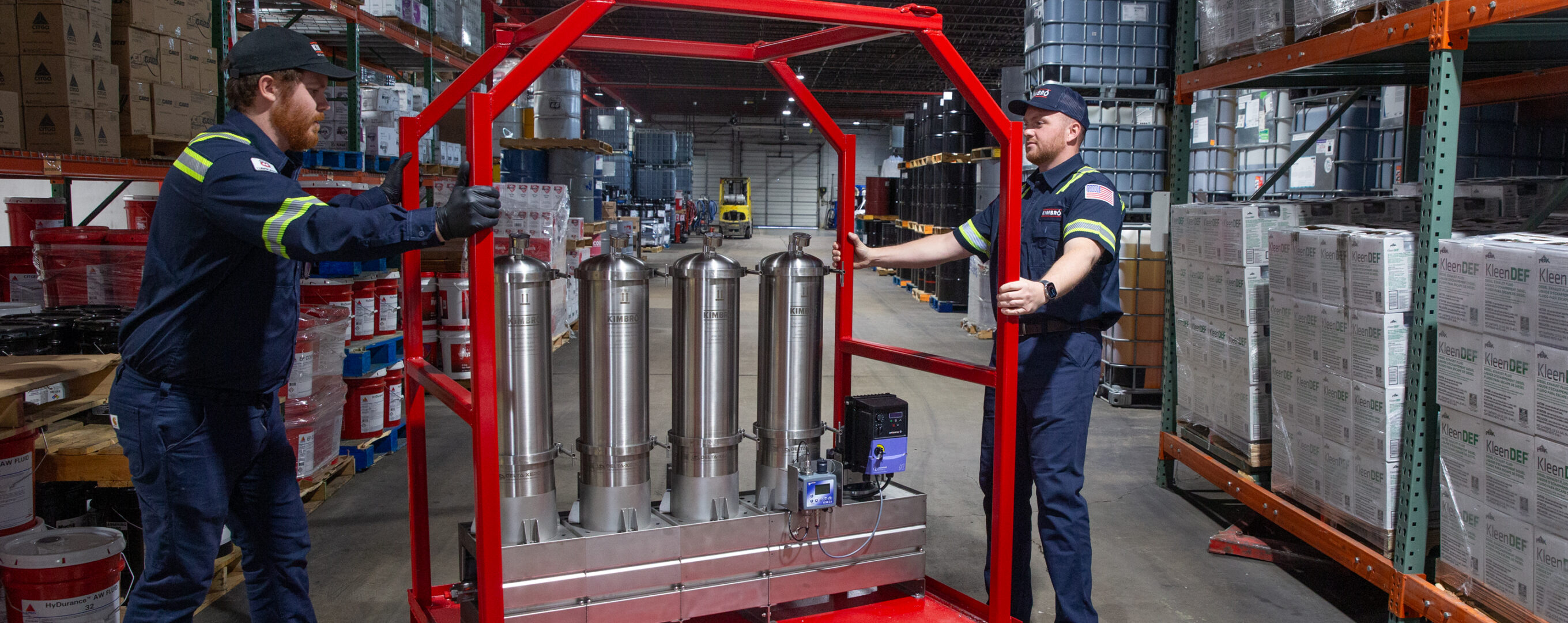 Two Kimbro technicians with a red filtration cart in the warehouse