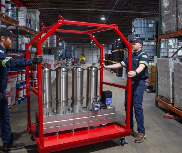 Two Kimbro technicians with a red filtration cart in the warehouse