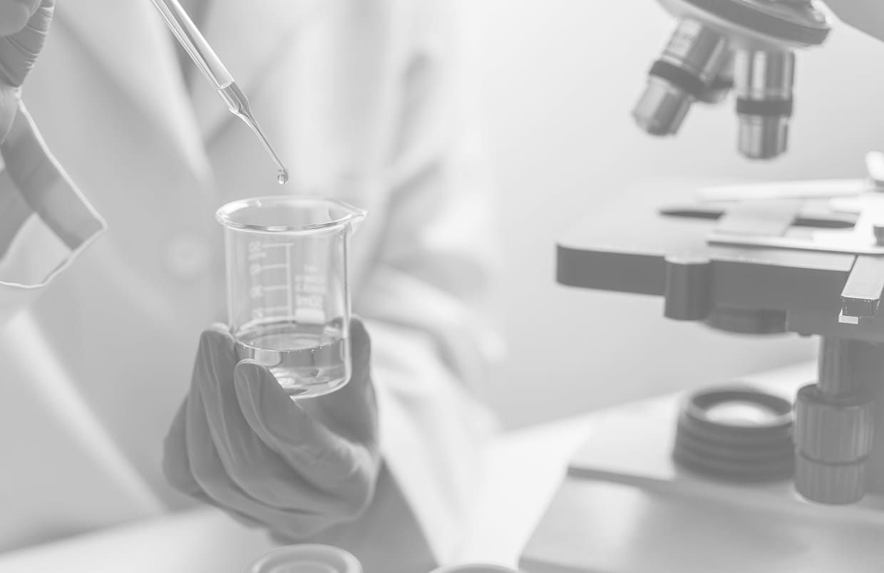Lab technician pouring an oil sample into a beaker for analysis