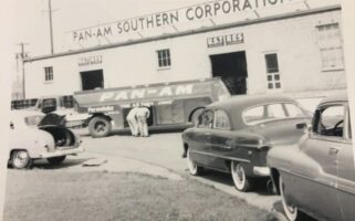 Historic photo of the Pan-Am Southern Corporation building with 1950s cars out front
