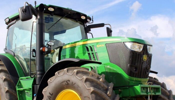 Green tractor working in a farm field