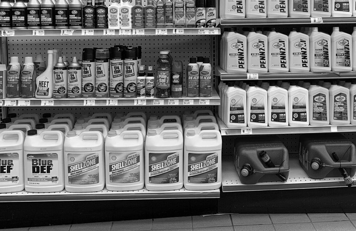 Convenience store shelves stocked with motor oil and DEF jugs
