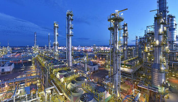 Chemical processing plant lit up at dusk