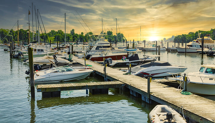Boats docked at a lake marina at sunset