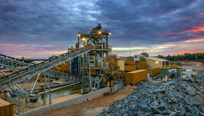 Mining processing plant with conveyors at sunset