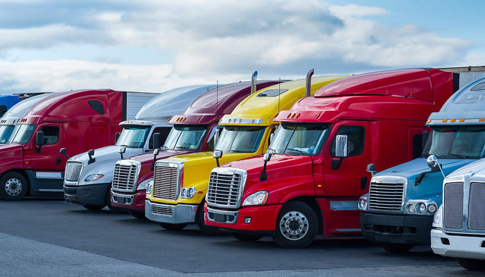 Row of semi-trucks parked side by side