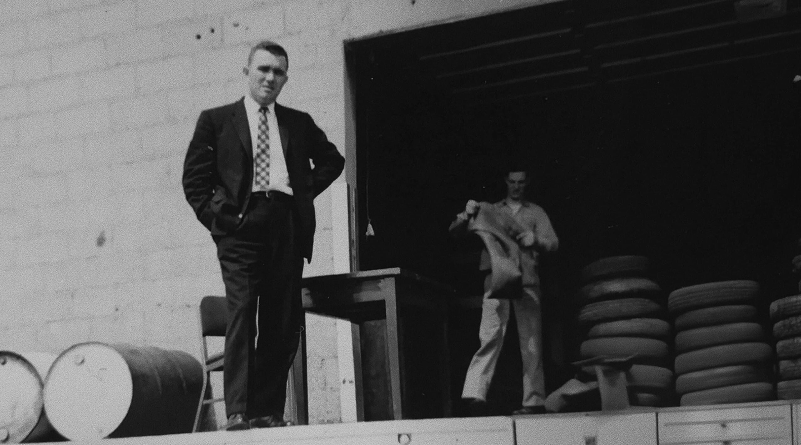 Historic black-and-white photo of the early Kimbro business with tires and oil drums