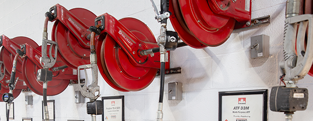 Red lubricant hose reels mounted on a wall