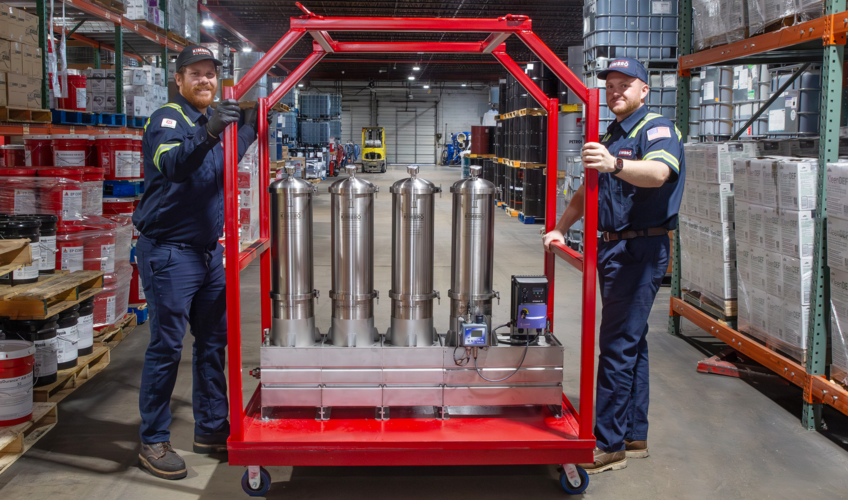 Two Kimbro technicians with a filtration cart in the warehouse