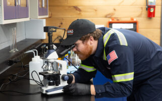 Kimbro lab technician examining an oil sample under a microscope