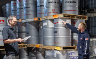 Two Kimbro employees checking lubricant drum inventory in the warehouse