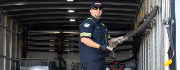 Kimbro technician handling a lubricant hose inside a service truck