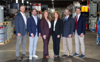 Kimbro team members in business attire standing in the warehouse